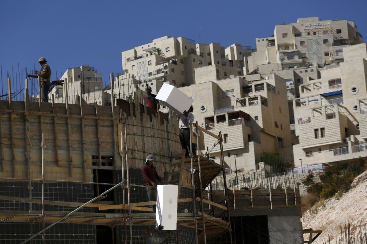 Palestinians work Monday at a construction site for new housing in the Arab East Jerusalem neighborhood of Jabal Abu Ghneim, where the Har Homa development was built in the late 1990s.
