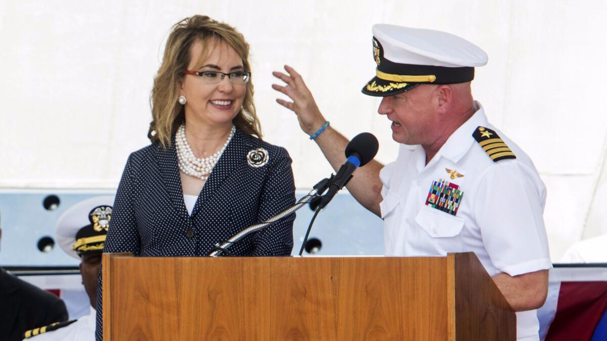 Former Rep. Gabrielle Giffords (D-Ariz.) and her husband, retired Navy Capt. Mark Kelly, share the podium during the commissioning of her namesake combat ship in Galveston, Texas.