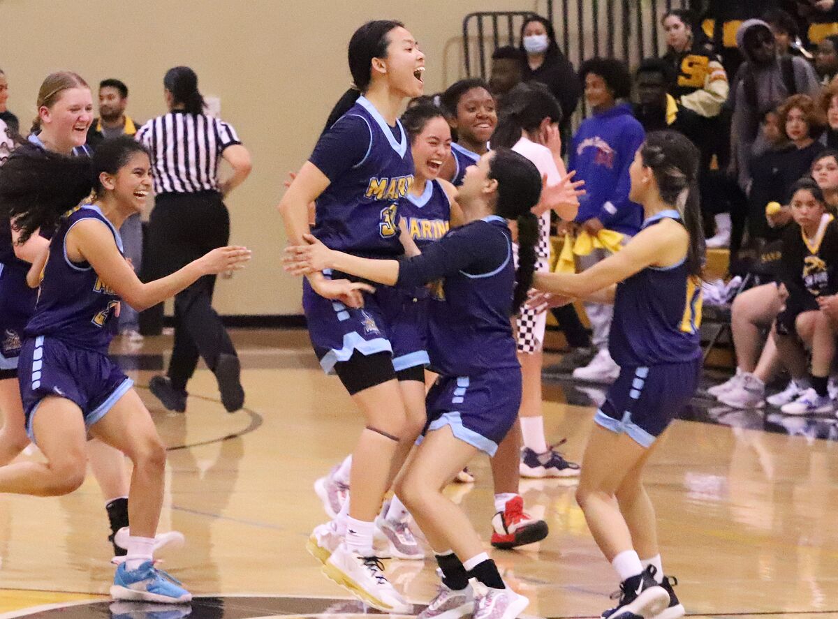 The Marina girls' basketball team celebrates after winning the CIF State Southern California Regional Division V final.