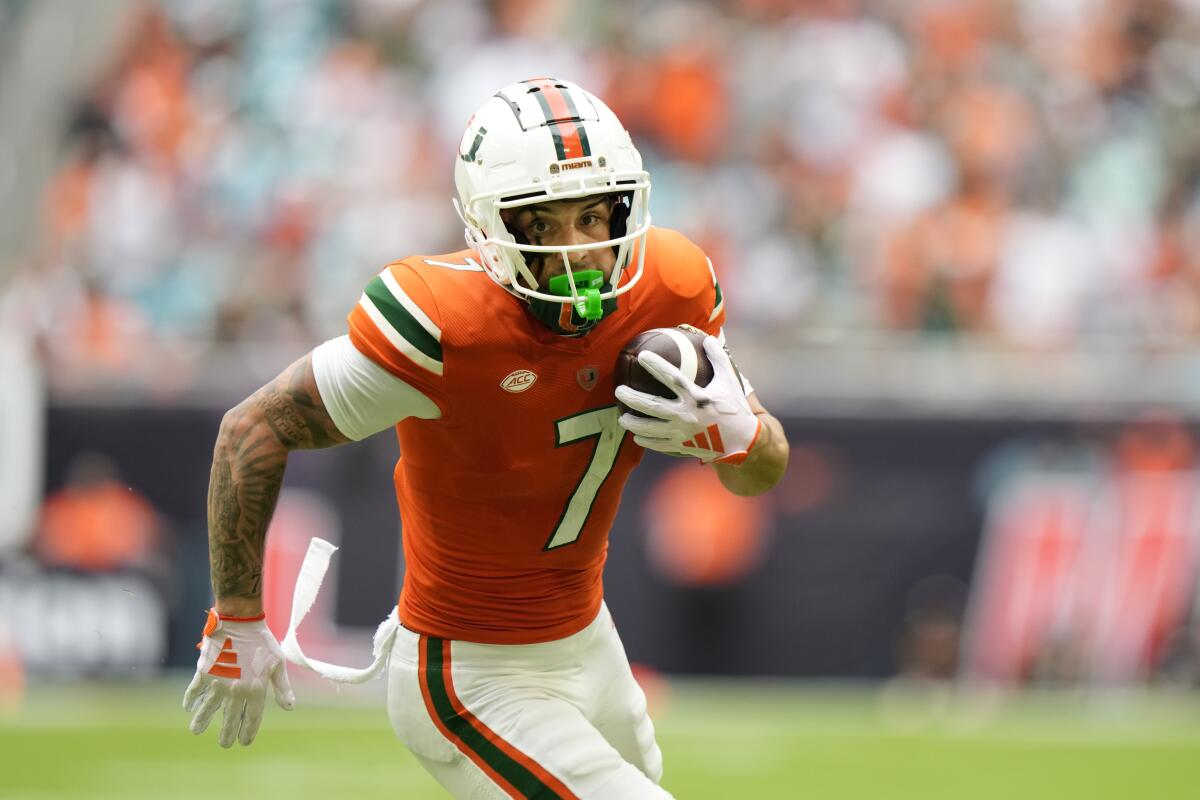 Miami wide receiver Xavier Restrepo runs in for a touch down during the first half of an NCAA college football game against Louisville, Saturday, Nov. 18, 2023, in Miami Gardens, Fla. (AP Photo/Wilfredo Lee)