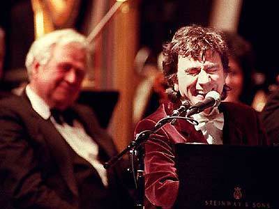Dudley Moore sings a whimsical number at the Cerritos Center for the Performing Arts in March 1996.