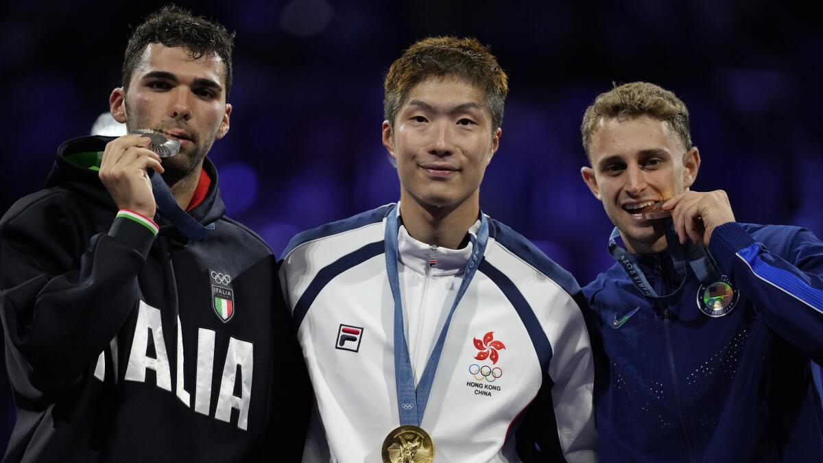 Hong Kong's Ka-long Cheung, winner of the gold medal in the men's individual foil, celebrates on the podium.