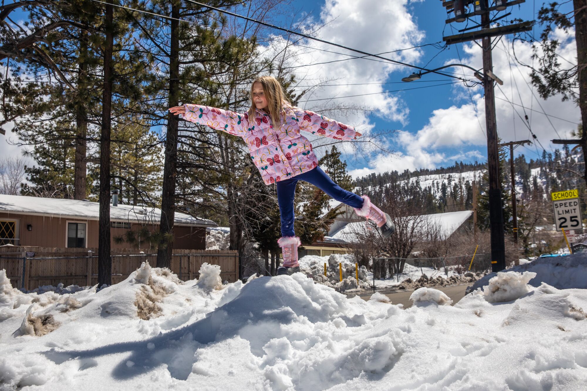 A girl plays in the snow on a neighborhood street in Big Bear.