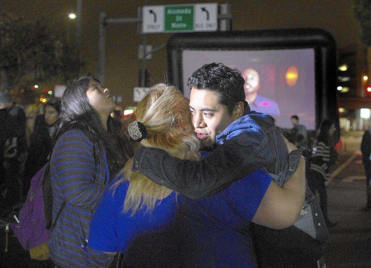 Armando Ibañez, 32, hugs a friend after President Obama's immigration address. The new policy won't help him and his mother.
