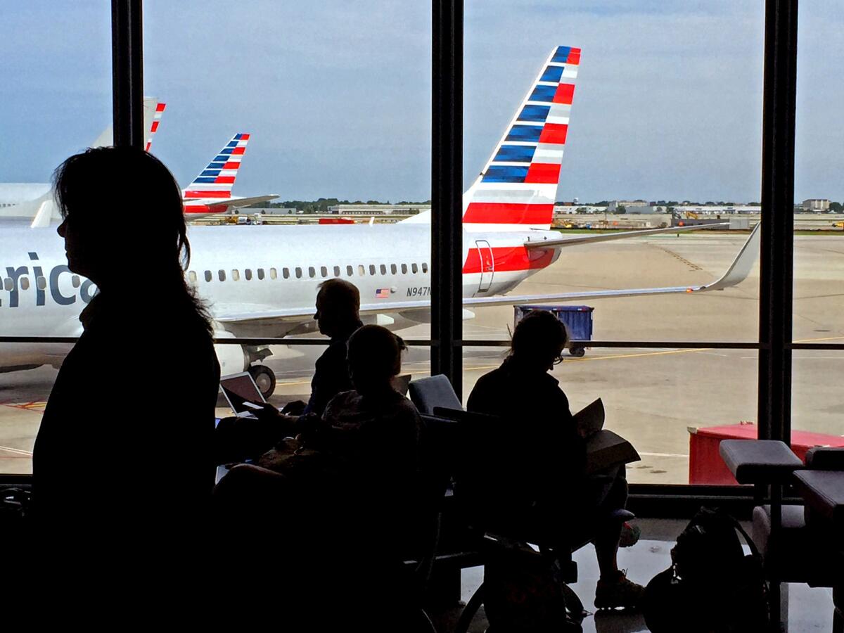 Travelers at Chicago O'Hare International Airport await their flights at the American Airlines terminal. American, Delta and United airlines have been accused by a lawmaker and others of conspiring to change booking policies to raise the cost of multi-city trips.