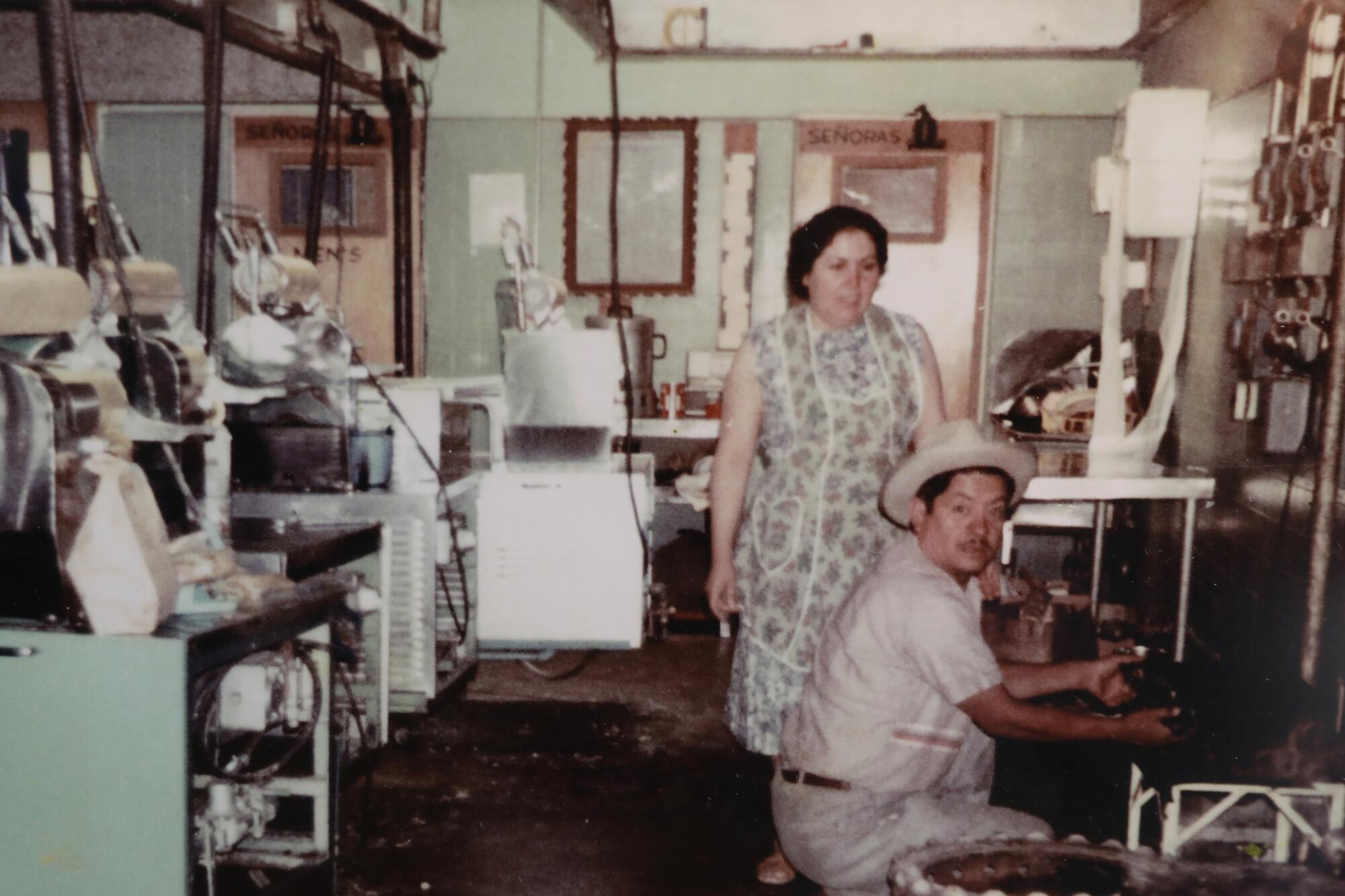 Old photo of a man and a woman in a factory space.