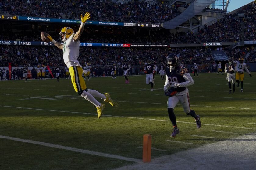 Green Bay Packers' Christian Watson reacts as he crosses the goal line after catching a touchdown pass during the second half of an NFL football game against the Chicago Bears Sunday, Dec. 4, 2022, in Chicago. (AP Photo/Charles Rex Arbogast)