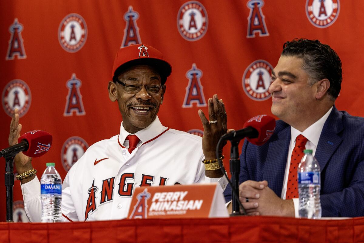 Angels manager Ron Washington, left, and general manager Perry Minasian share a light moment.