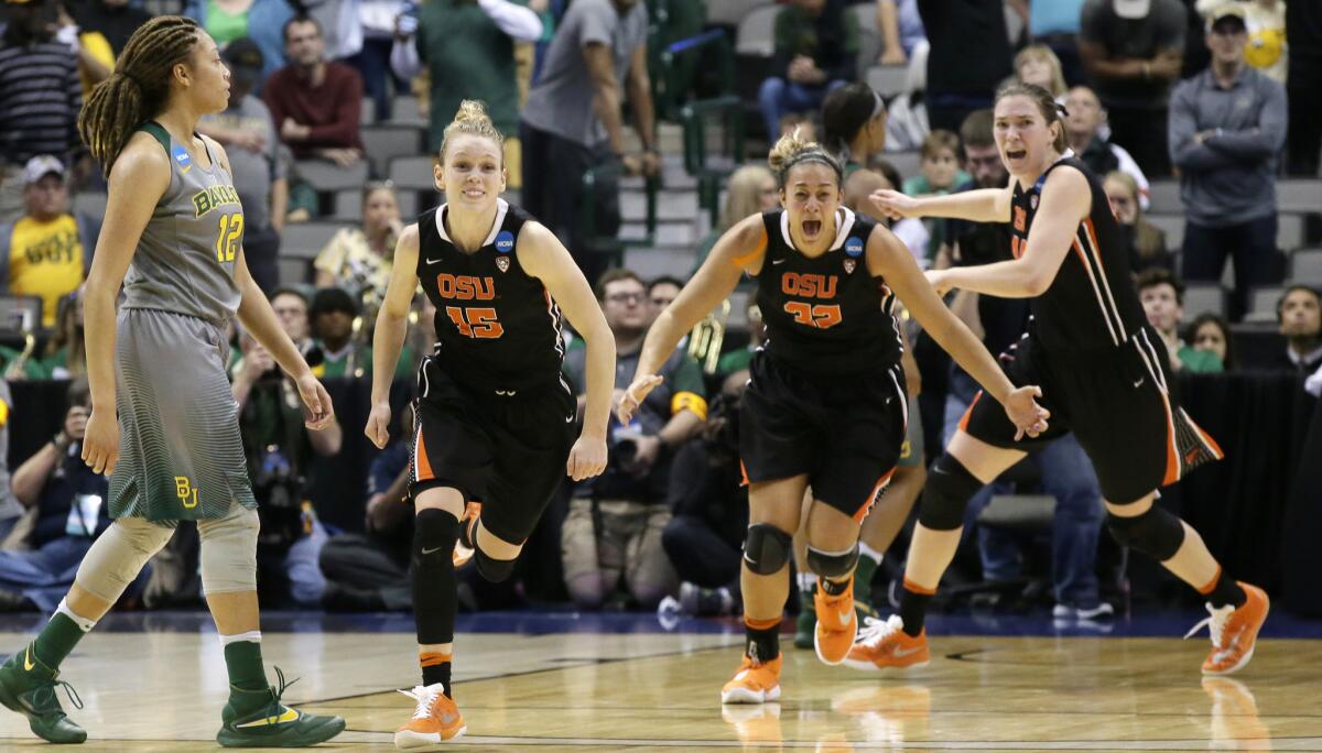 Oregon State guard Jamie Weisner (15) runs with teammates Deven Hunter (32) and Ruth Hamblin (44) past Baylor guard Alexis Prince (12) as they celebrate their regional final victory and berth in the Final Four.