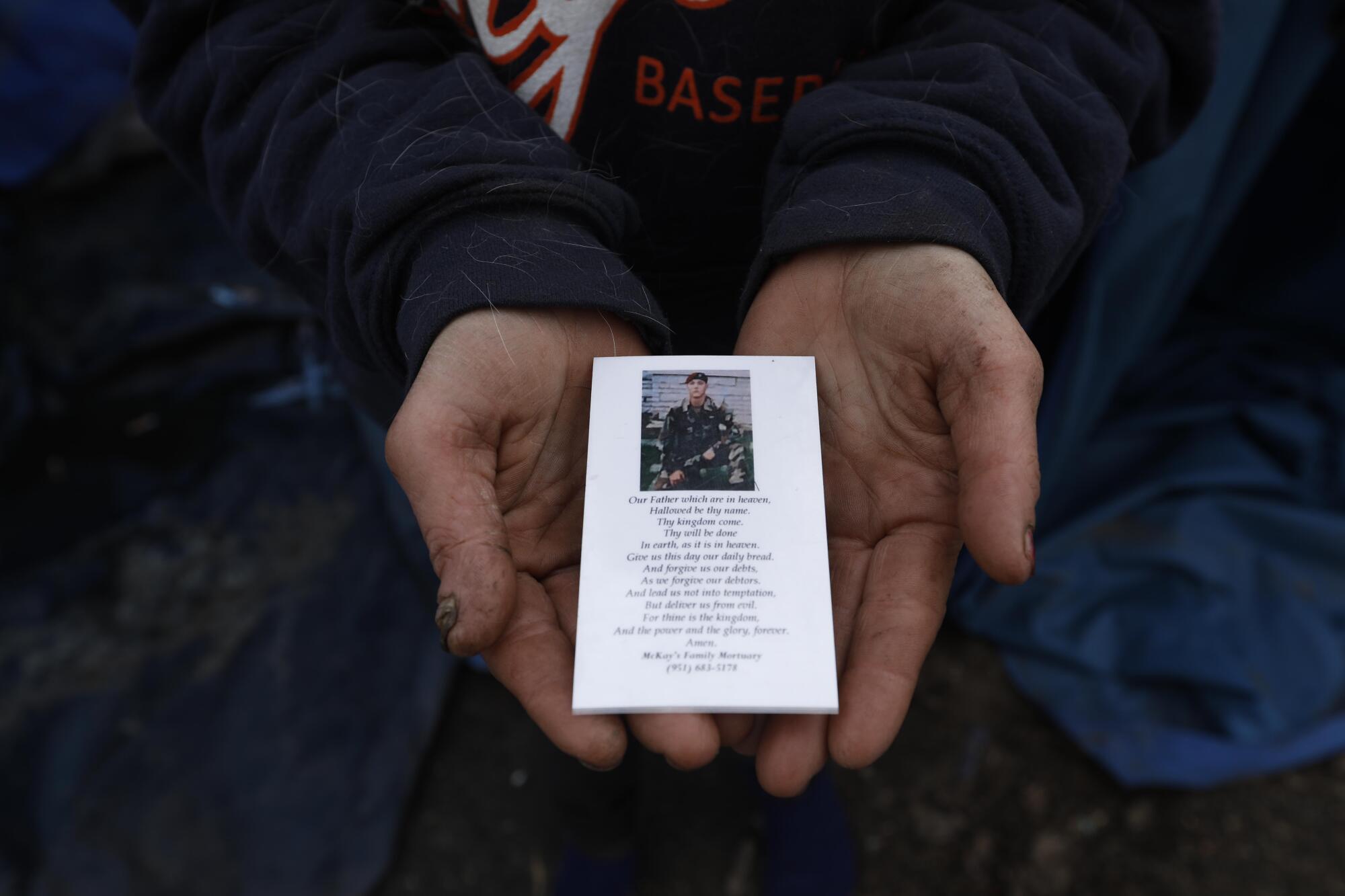 Melissa Millner holds a memorial card