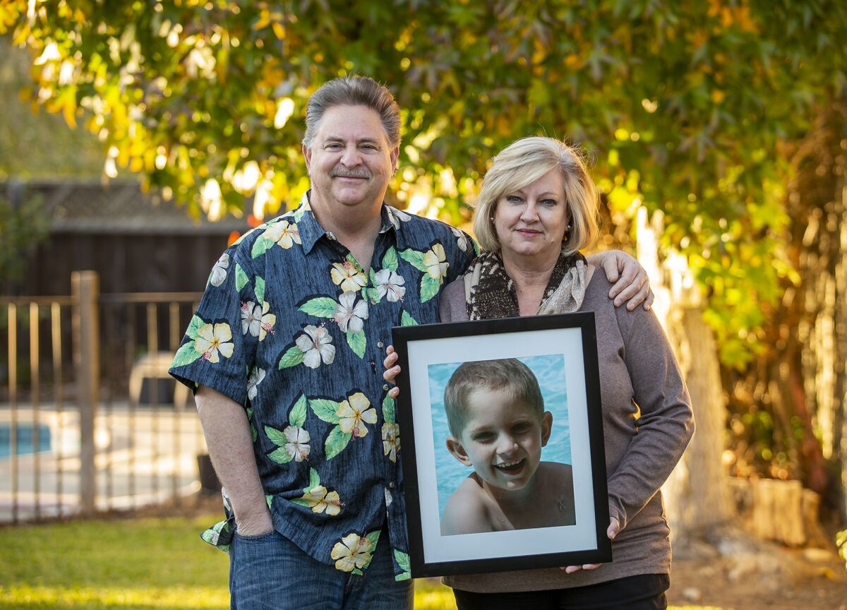 Richard and Andrea Dunn hold a photograph of their late son Julian, who died of medulloblastoma in 2013.