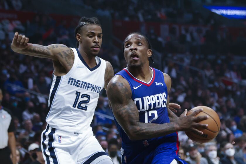 Los Angeles Clippers guard Eric Bledsoe (12) drives past Memphis Grizzlies guard Ja Morant (12) during the first half of an NBA basketball game, Saturday, Oct. 23, 2021, in Los Angeles. (AP Photo/Ringo H.W. Chiu)