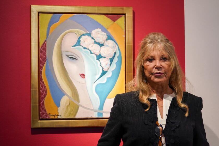 Pattie Boyd poses next to the original artwork by E. Frandsen De Schomberg, used for the cover of Derek and the Dominoes album 'Layla and Other Assorted Love Songs' as part of The Pattie Boyd Collection at Christie's, in London, Thursday, March 14, 2024. The artwork is estimated to sell £40,000-60,000. (AP Photo/Alberto Pezzali)