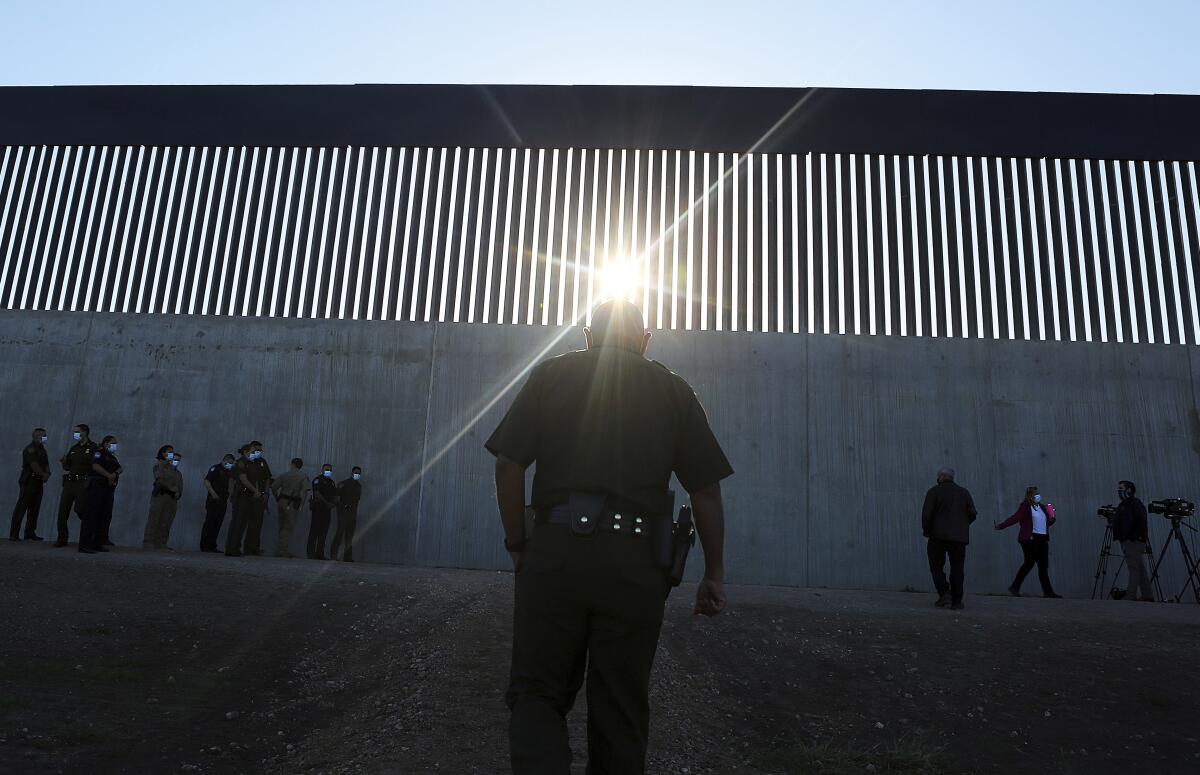 Un agente de la Patrulla Fronteriza de Estados Unidos camina hacia una nueva sección del muro 