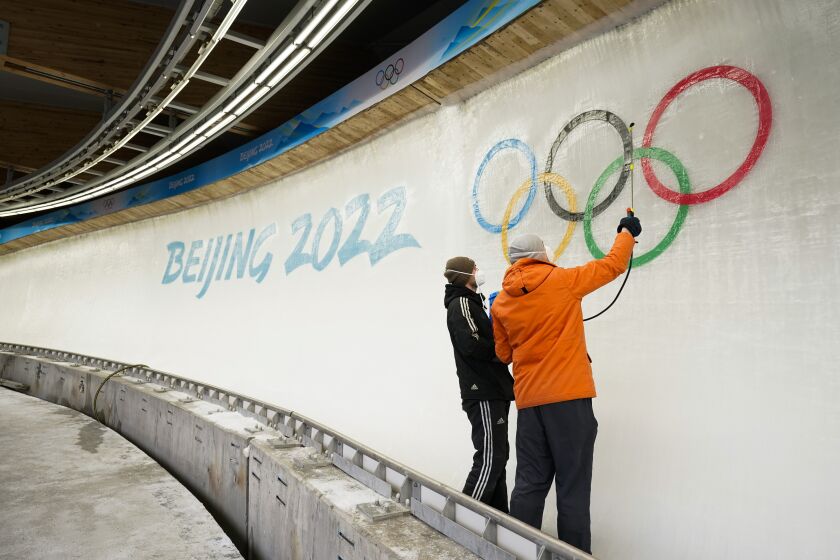 Two ice makers spray water after installing a sub-glacial Beijing 2022 logo on the track.