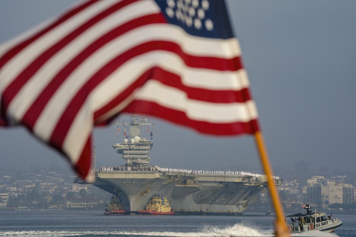 The aircraft carrier Abraham Lincoln makes her way into San Diego Bay as the strike group returns from deployment on Thursday