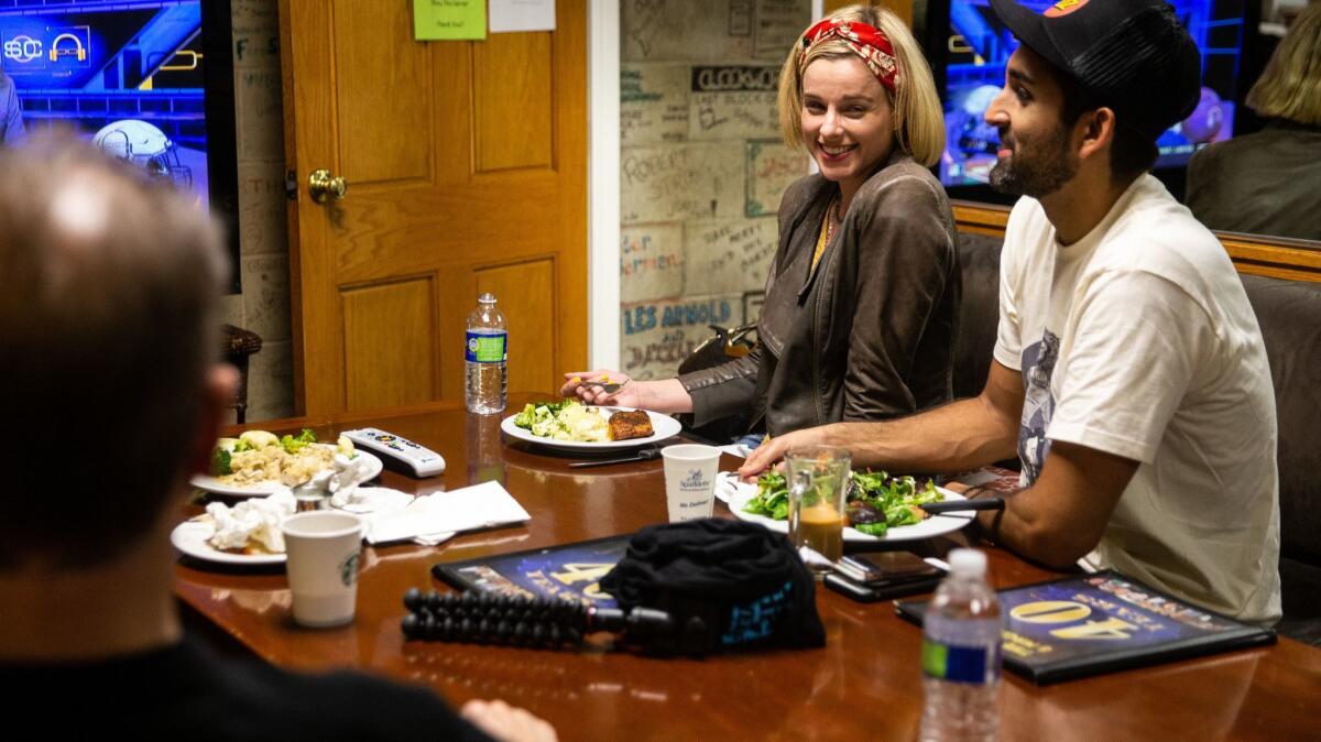 Comedian Erica Rhodes chats while eating dinner with fellow comedian Feraz Ozel in the green room of The Comedy and Magic Club in Hermosa Beach.