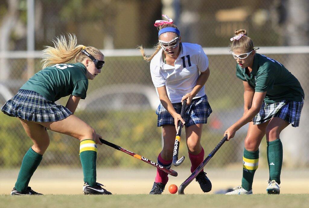 Edison High's Bianca Mills, left, and teammate Kristen Shklanko, right, double team Newport Harbor's Alex Palmer (11) during the first half in a Sunset League game at Davidson Field on Tuesday.