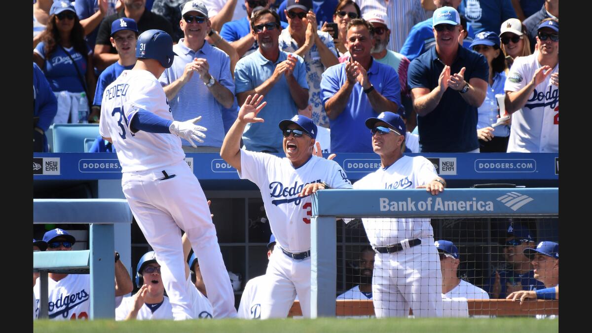 Dodgers outfielder Joc Pederson celebrates his grand slam with Manager Dave Roberts.