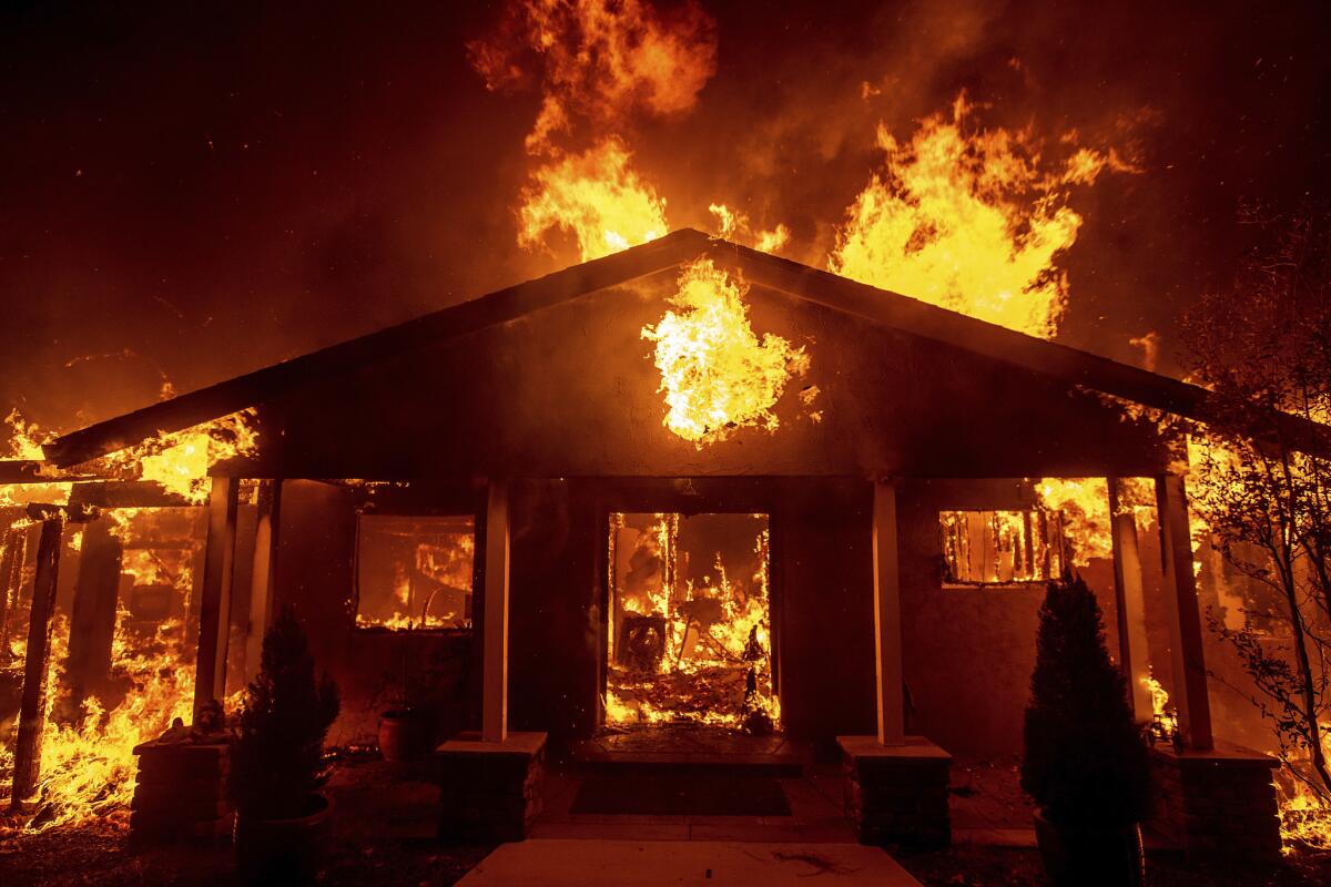 Flames engulf a home in Paradise, Calif., during the Camp fire in 2018.