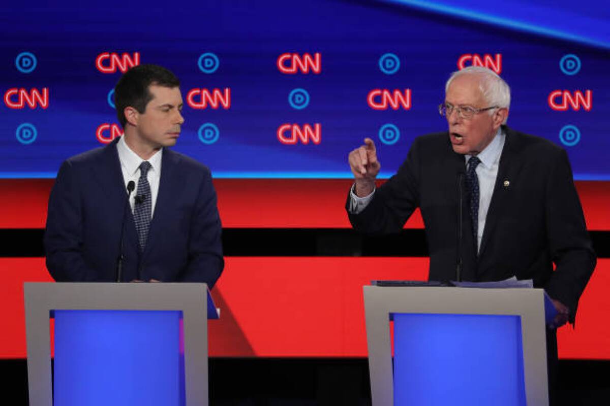 Bernie Sanders speaks while Pete Buttigieg listens during the July 30 Democratic presidential candidates debate in Detroit.