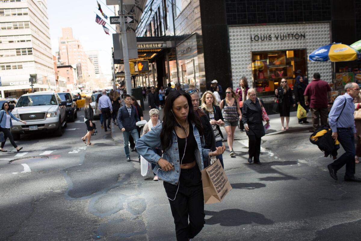 Shoppers walk along Lexington Avenue in New York City on April 29.