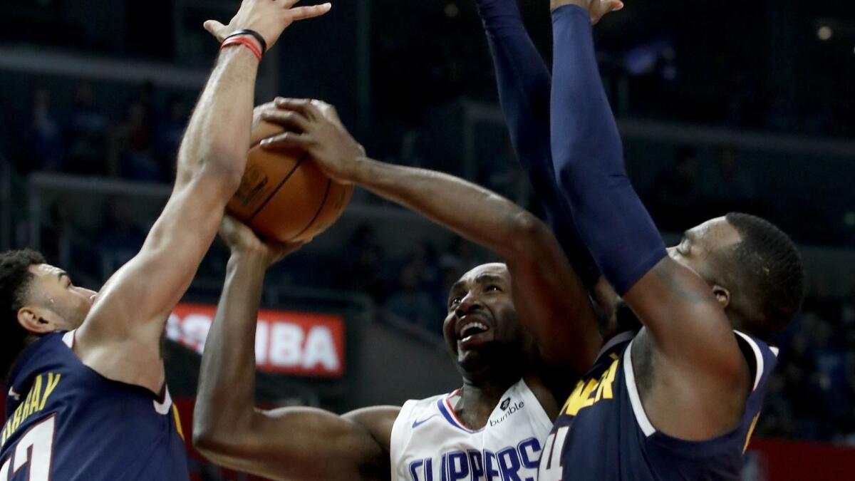 The Clippers' Luc Mbah a Moute goes up for a shot against the Nuggets' Jamal Murray, left, and Paul Millsap on Oct. 17 at Staples Center.