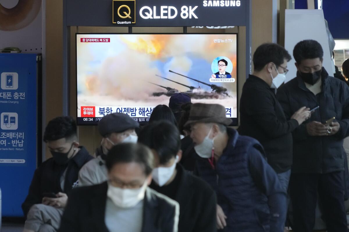 A news program on a TV at the Seoul Railway Station shows a file image of North Korea's military exercise.