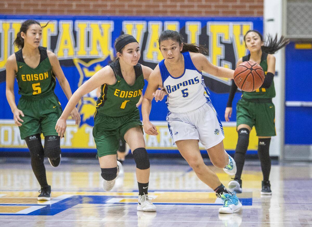 Fountain Valley's Kat Luu, right, dribbles the ball up the court against Edison's Noelle Duffey in a Sunset Conference crossover game at home on Thursday.