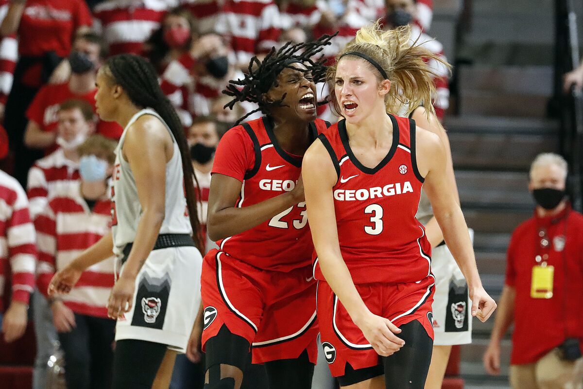 Georgia's Sarah Ashlee Barker (3) celebrates a three-point basket with teammate Que Morrison (23) during the second half of an NCAA college basketball game against North Carolina State, Thursday, Dec. 16, 2021, in Raleigh, N.C. (AP Photo/Karl B. DeBlaker)