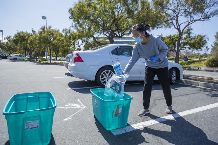 Siman Peng donates medical supplies at a community drive run by UC Irvine med students to collect personal protective equipment including masks, sanitizer, gloves and other medical supplies.