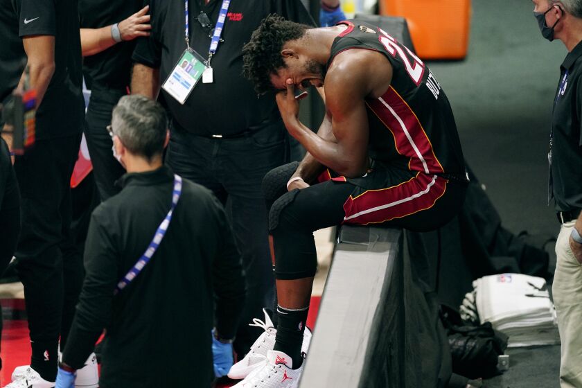 Miami Heat's Jimmy Butler (22) pauses after an apparent injury during the first half of Game 1 of basketball's NBA Finals Wednesday, Sept. 30, 2020, in Lake Buena Vista, Fla. (AP Photo/Mark J. Terrill)
