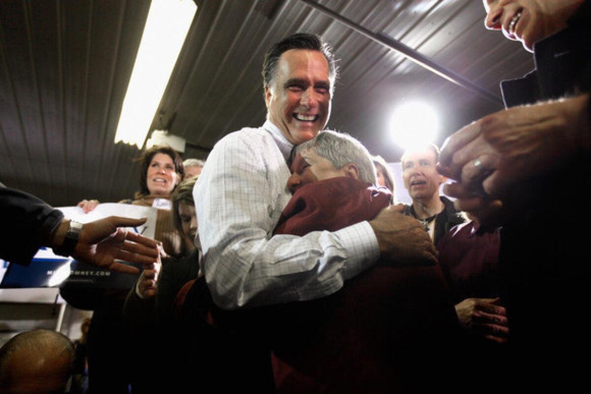 Mitt Romney hugs supporter Joni Scotter during a campaign rally at Pate Asphalt in Marion, Iowa.