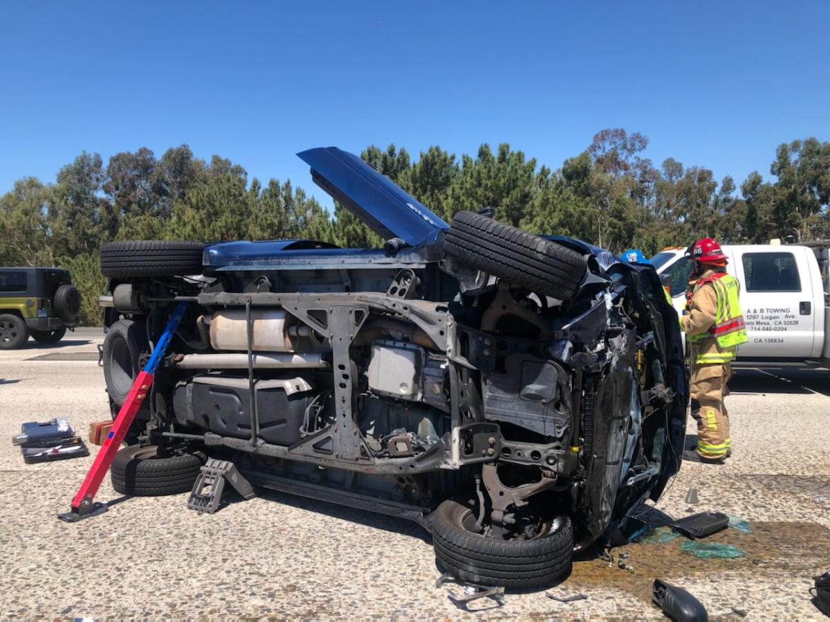 An SUV sits on its side on the 55 Freeway in Costa Mesa Thursday following a solo vehicle rollover near the 73 Freeway.