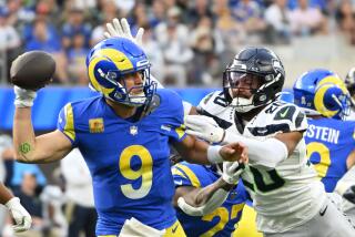 Rams' Matthew Stafford is pressured by Seattle Seahawks' Julian Love.