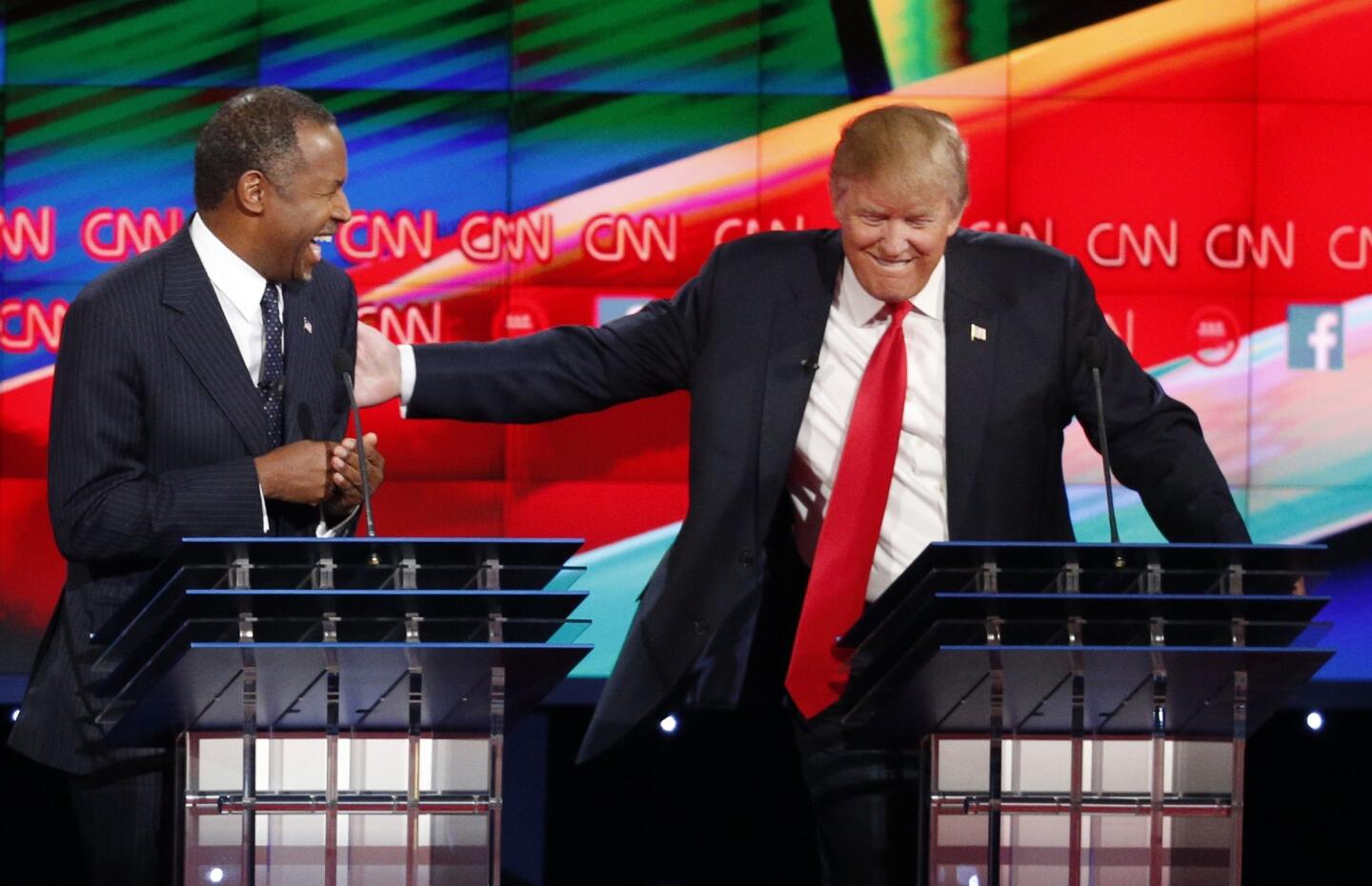 Ben Carson, left, and Donald Trump laugh during the Republican presidential debate at the Venetian Hotel & Casino in Las Vegas.