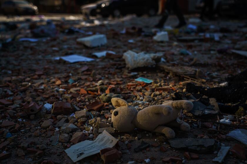 A stuffed dog sits in the debris fallen off a building after a rocket struck it.