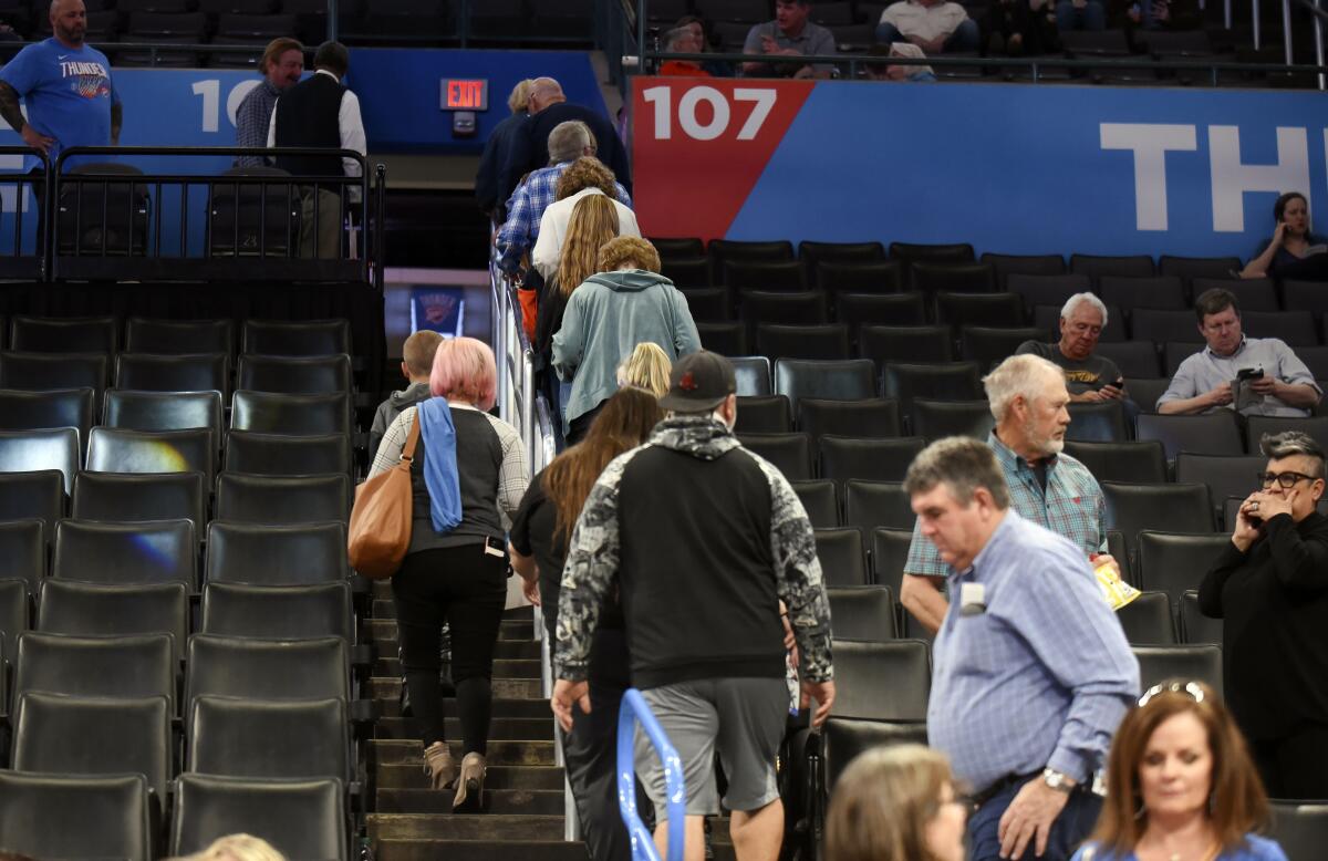 Basketball fans leave Chesapeake Energy Arena after Wednesday's game between the Oklahoma City Thunder and Utah Jazz was postponed.