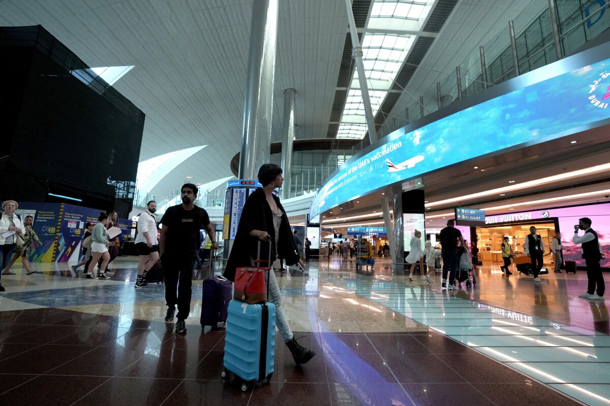 FILE - Passengers arrive at the Dubai Airport terminal 3, in Dubai, United Arab Emirates, on Oct. 25, 2022. Just as soccer fans going to a game in a European city might take a metro, tens of thousands of foreigners attending the World Cup in Qatar this month are commuting to matches by airplane. (AP Photo/Kamran Jebreili, File)