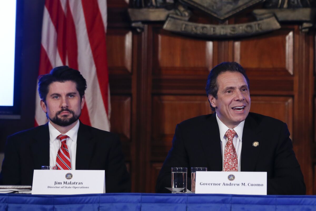 FILE - Former Director of State Operations Jim Malatras, left, listens to comments by Gov. Andrew Cuomo during a cabinet meeting Wednesday, Dec. 17, 2014, in Albany, N.Y. Malatras said, Thursday, Dec. 9, he would resign from his current job as New York state public university system Chancellor amid harsh criticism for his actions when he was a top aide to former Gov. Andrew Cuomo. (AP Photo/Mike Groll, File)