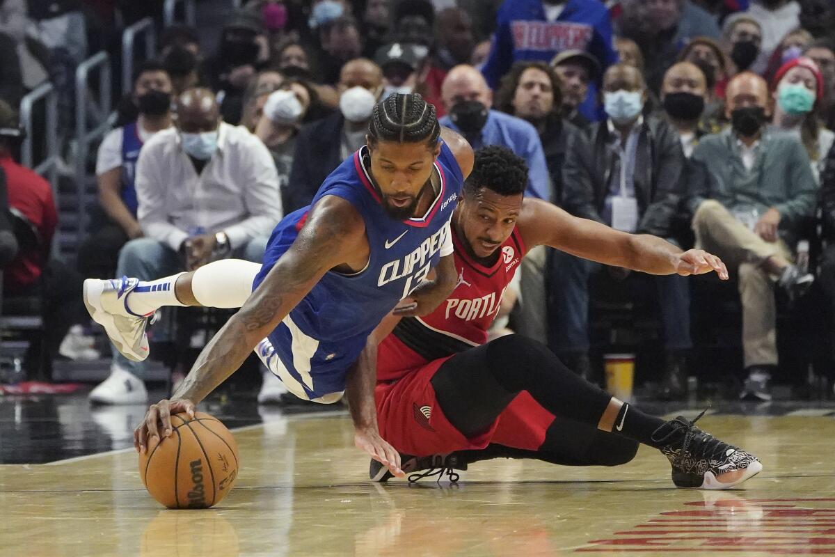 Clippers guard Paul George recovers the ball in front of Trail Blazers guard CJ McCollum 