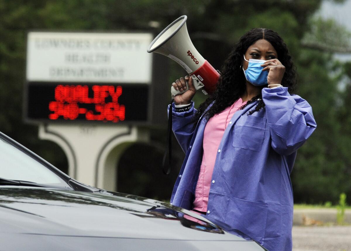 Healthcare worker Tonya Wilkes adjusts her mask at a testing site in Hayneville, Ala.