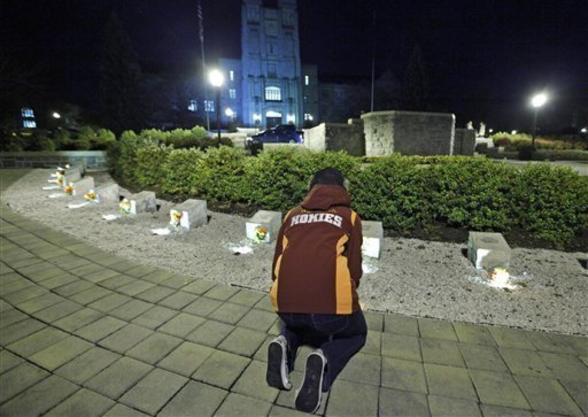 A student participates in an impromptu candlelight vigil in front of the 4/16 memorial on the campus of Virginia Tech after two shootings on the campus in Blacksburg, Va., Thursday, Dec. 8, 2011. A gunman killed a police officer and then apparently shot himself to death nearby in a baffling attack that shook up the campus nearly five years after it was the scene of the deadliest shooting rampage in modern U.S. history. (AP Photo/Steve Helber)