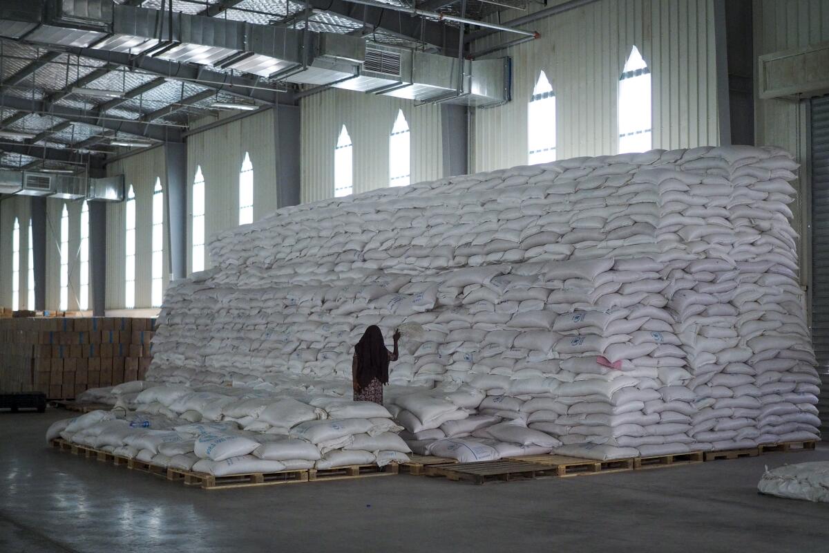 A worker tallies sacks of food.