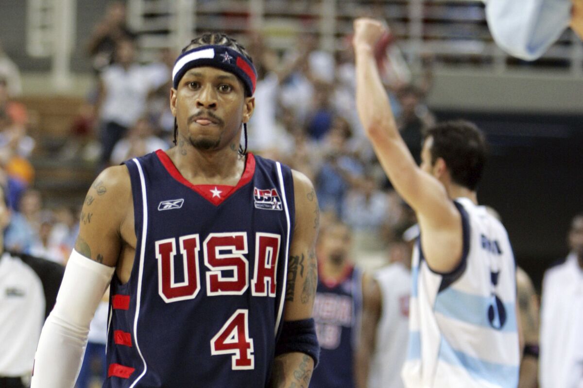 FILE - In this Aug. 27, 2004, file photo, USA's Allen Iverson (4) walks off the court as Argentina's Emanuel Ginobili celebrates at the end of their semifinal basketball game at the Olympic Indoor Hall during the 2004 Olympic Games in Athens, Greece. (AP Photo/Michael Conroy, File)