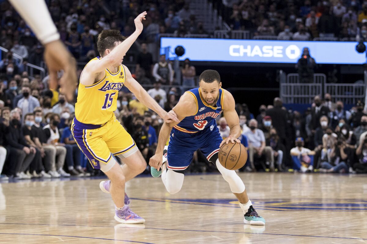 Golden State's Stephen Curry drives against the Lakers' Austin Reaves (15) during the second half Feb. 12, 2022. 