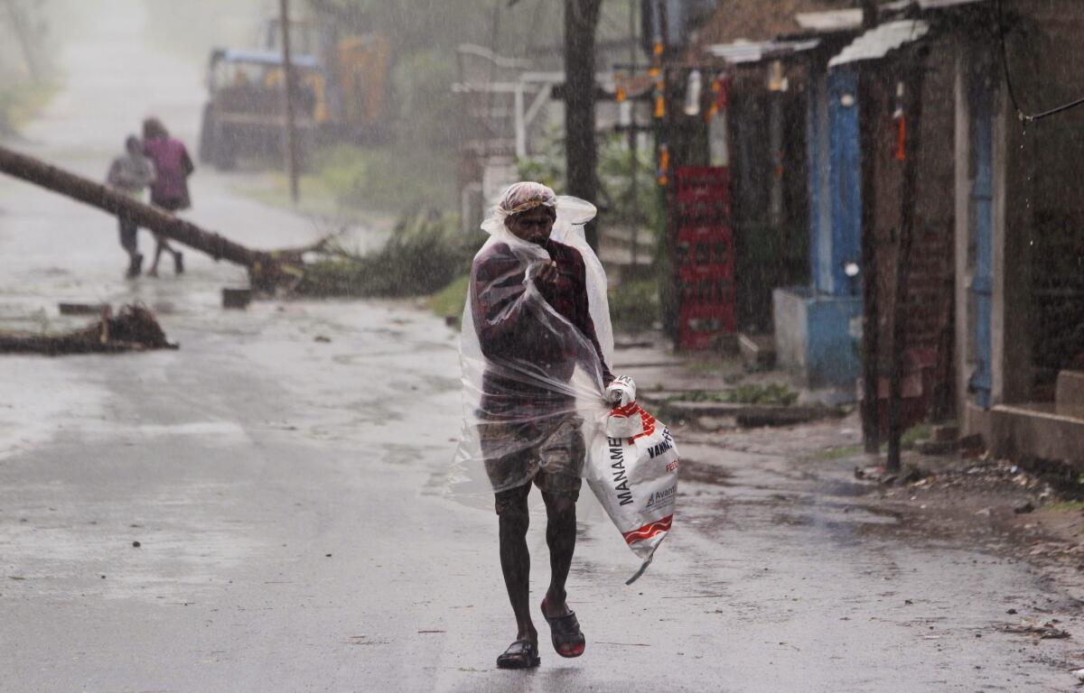 A man walks in the rain ahead of Cyclone Amphan's making landfall May 20 in the eastern Indian state of Orissa. 