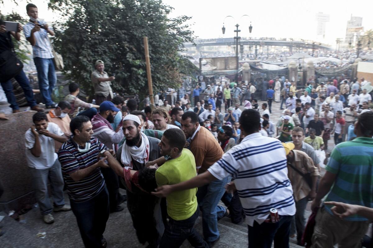 An injured supporter of deposed President Mohamed Morsi is carried into the Fatih Mosque at Ramses Square.