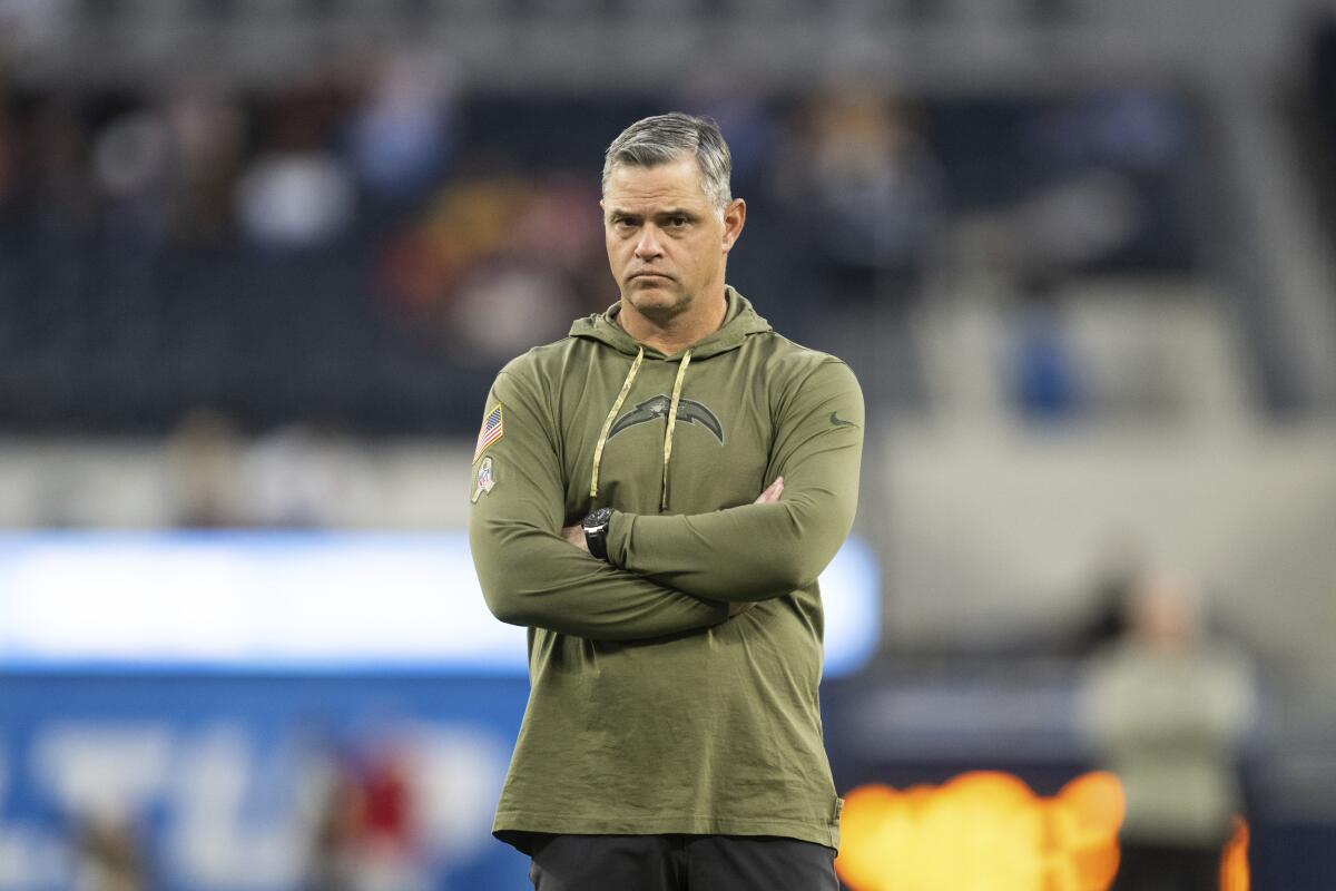 Chargers offensive coordinator Joe Lombardi watches players warm up before a game.
