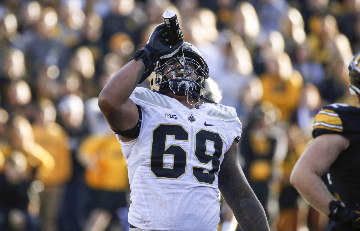 Purdue offensive lineman Greg Long pours a can of beer over his face after an Iowa fan tossed the beer onto the field during the third quarter of an NCAA college football game Saturday, Oct. 16, 2021, in Iowa City, Iowa. Purdue won 24-7. (Bryon Houlgrave/The Des Moines Register via AP)